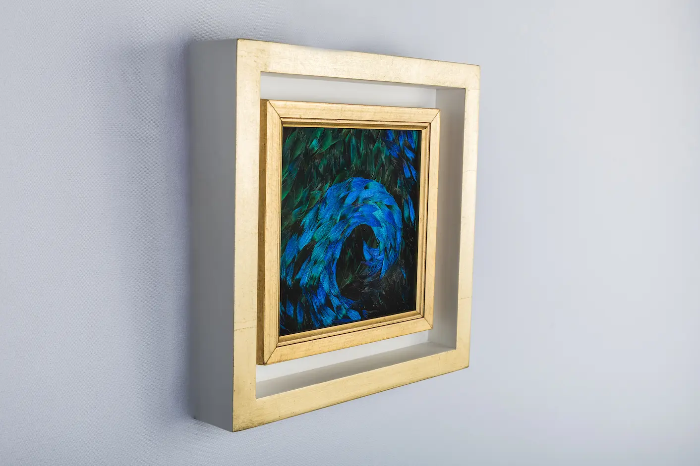 Blue wave painting made from natural peacock feathers in blue and blue/green on the side