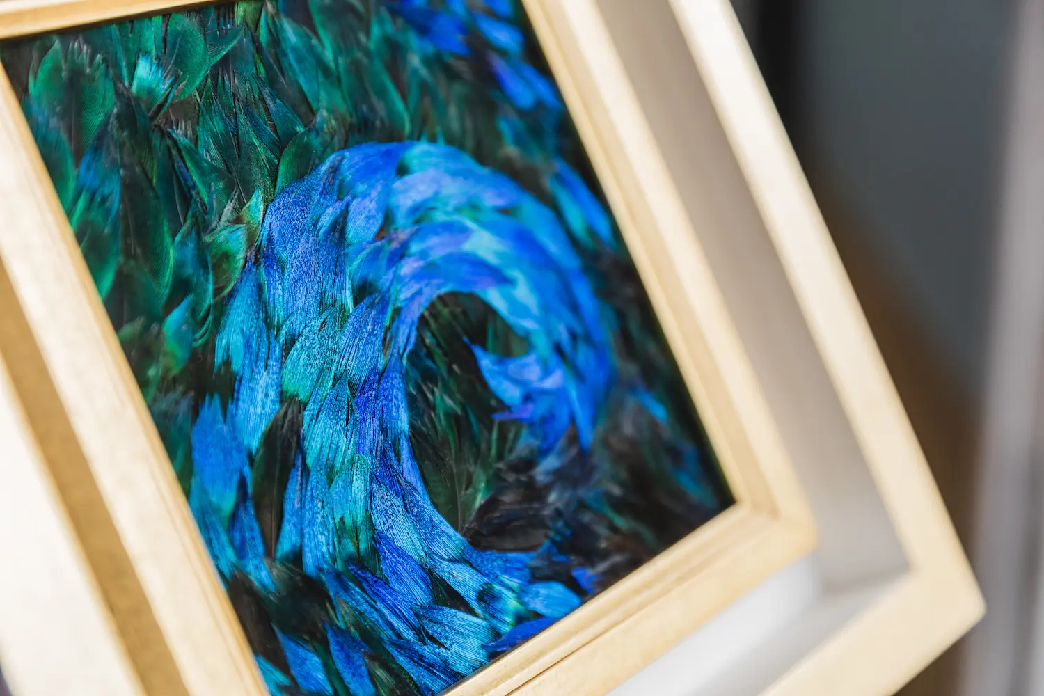 Blue wave painting made from natural blue and blue/green peacock feathers